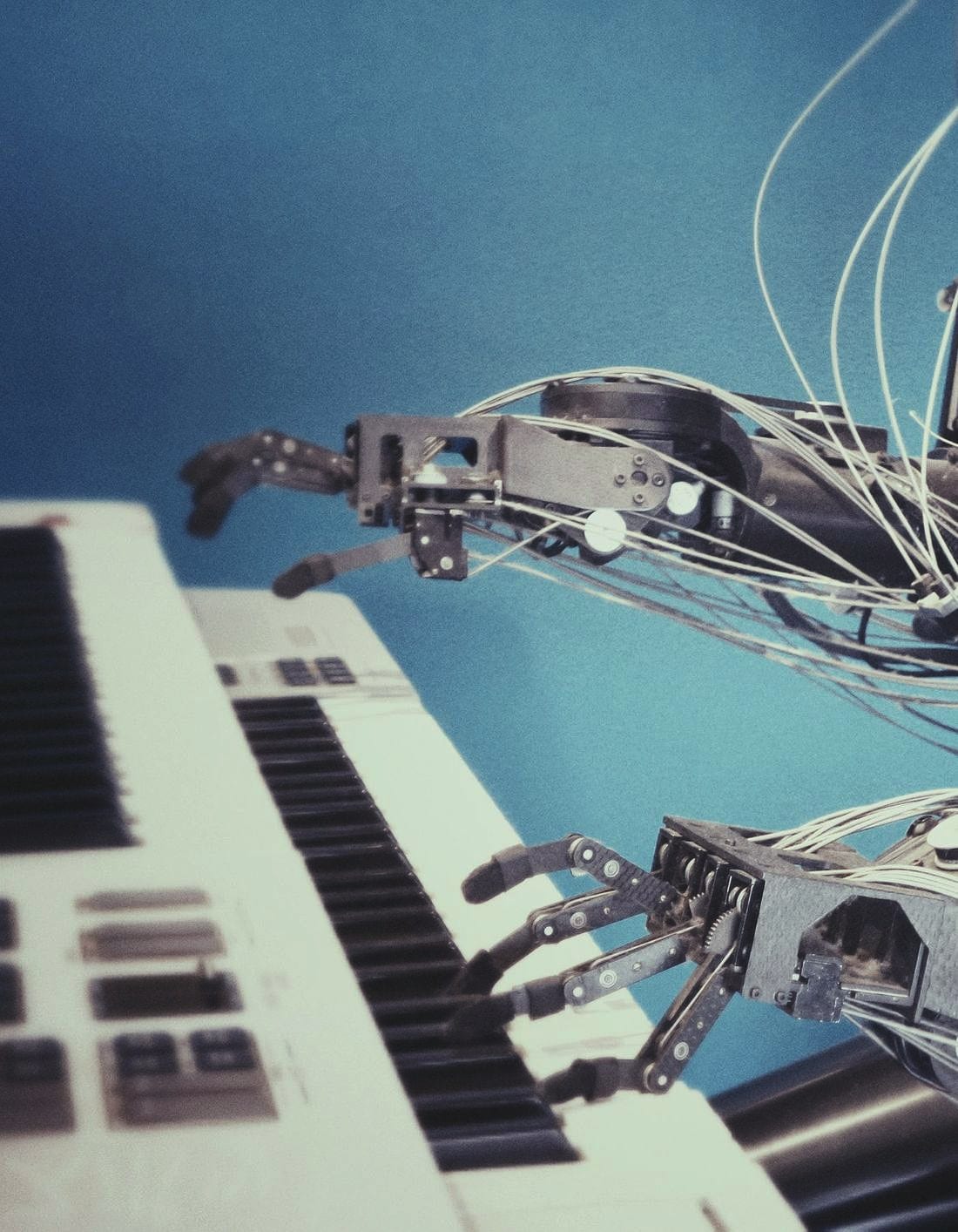 A robotic hand playing the keys of a piano