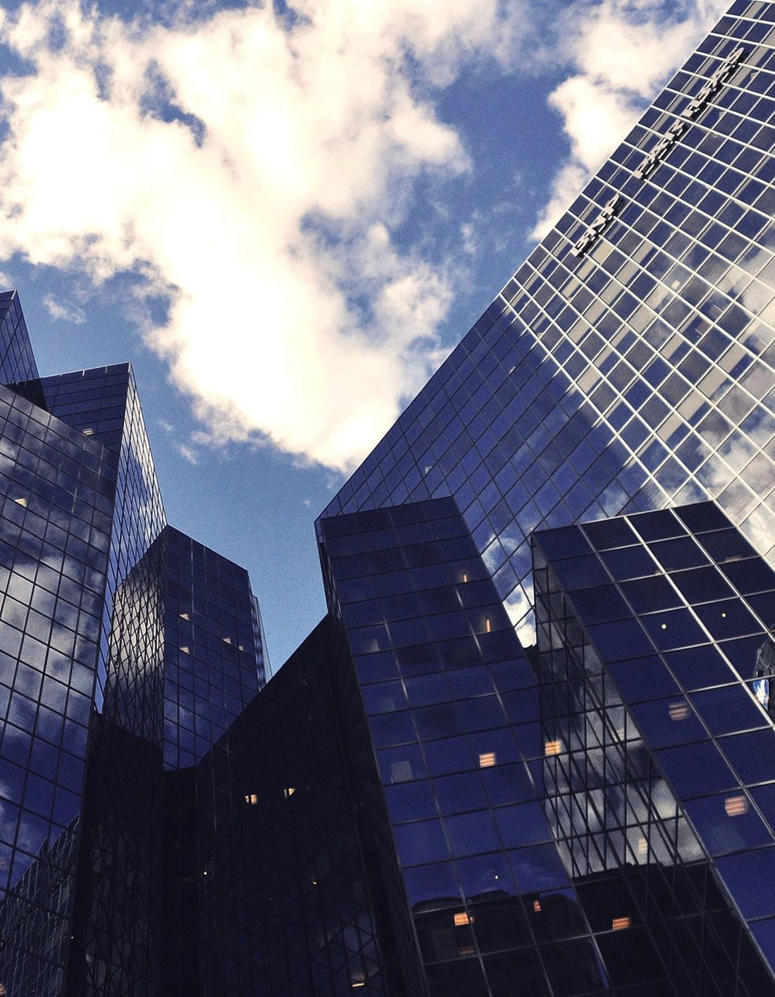 Glass office towers seen from the street, looking up