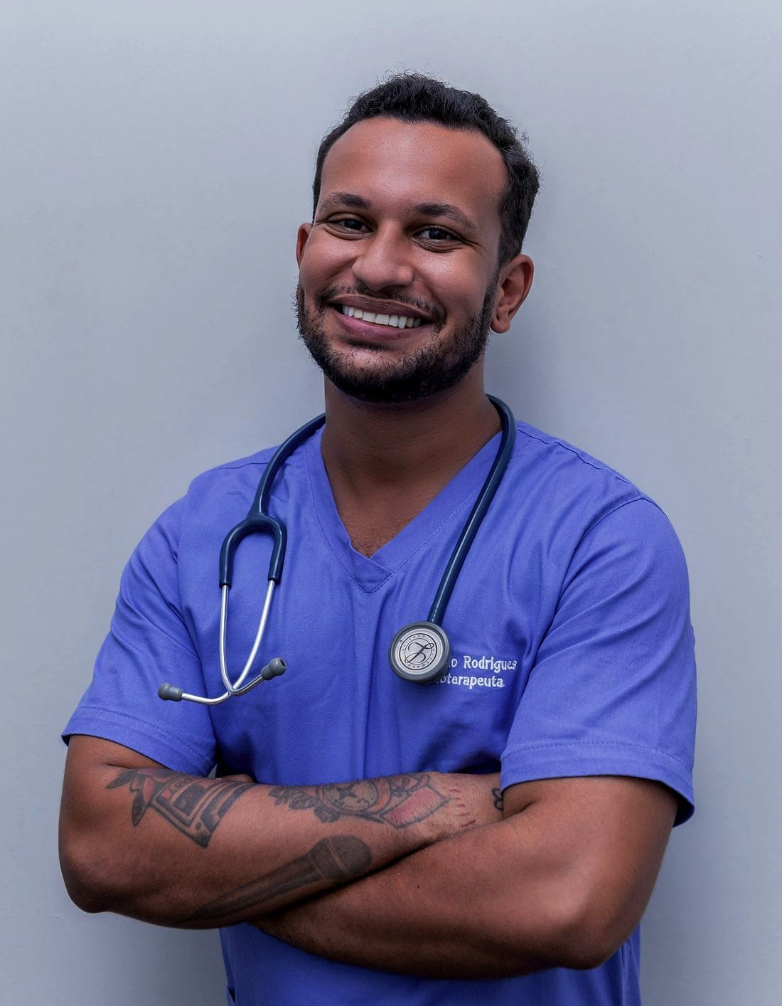 A nurse in scrubs with a stethoscope around their neck