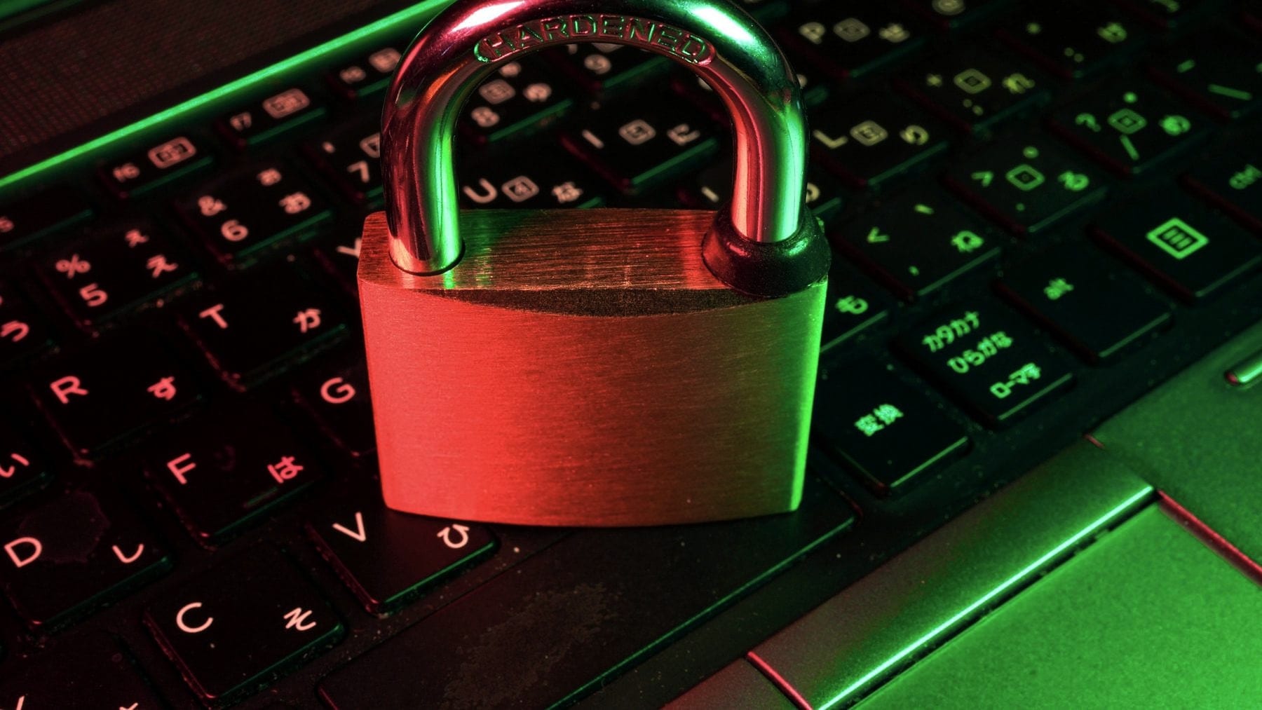 A padlock sitting closed on a backlit keyboard
