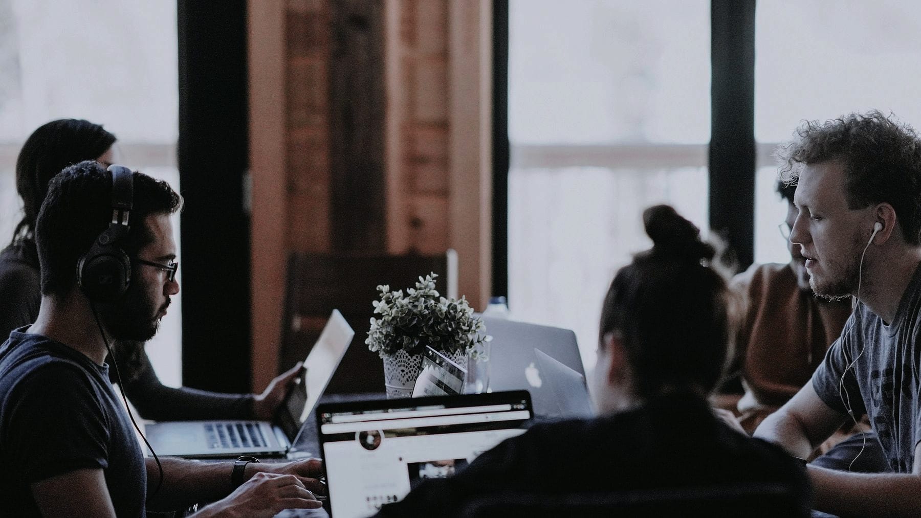 A small team working at laptops across a loft office