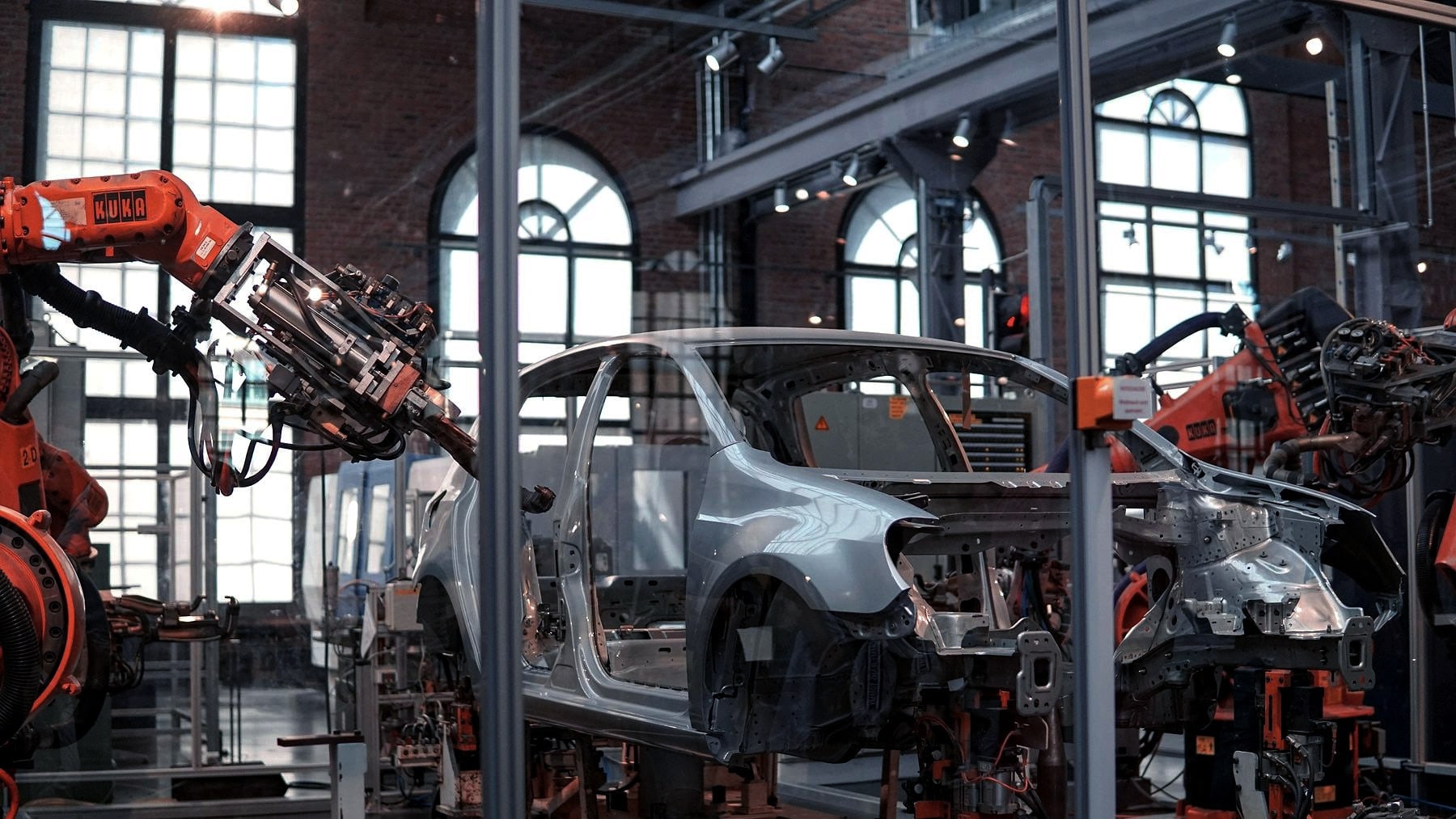 Robot arms working a body shell along an assembly line