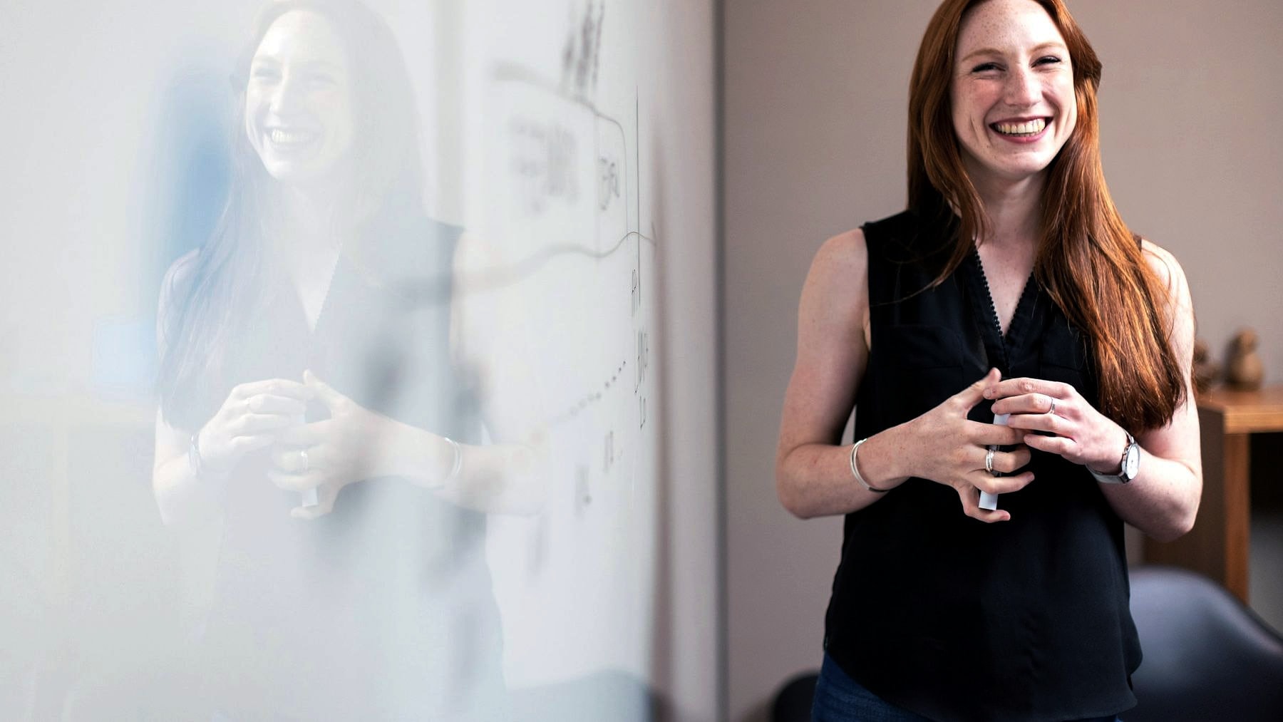 Someone leading a session at a glass whiteboard