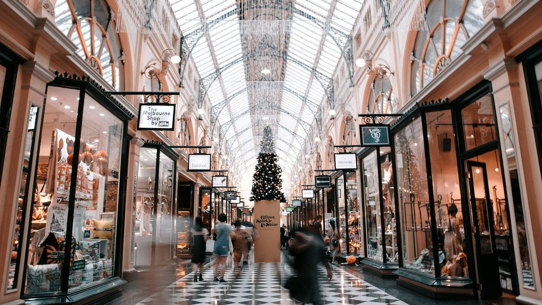 Shoppers moving through a covered retail arcade