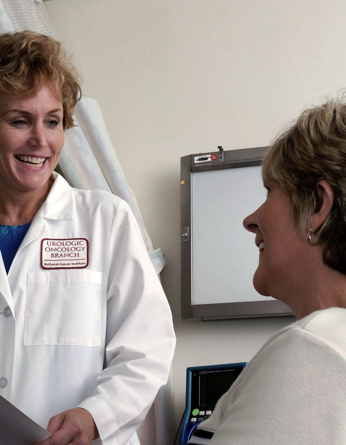 A doctor talking a patient through notes on a clipboard