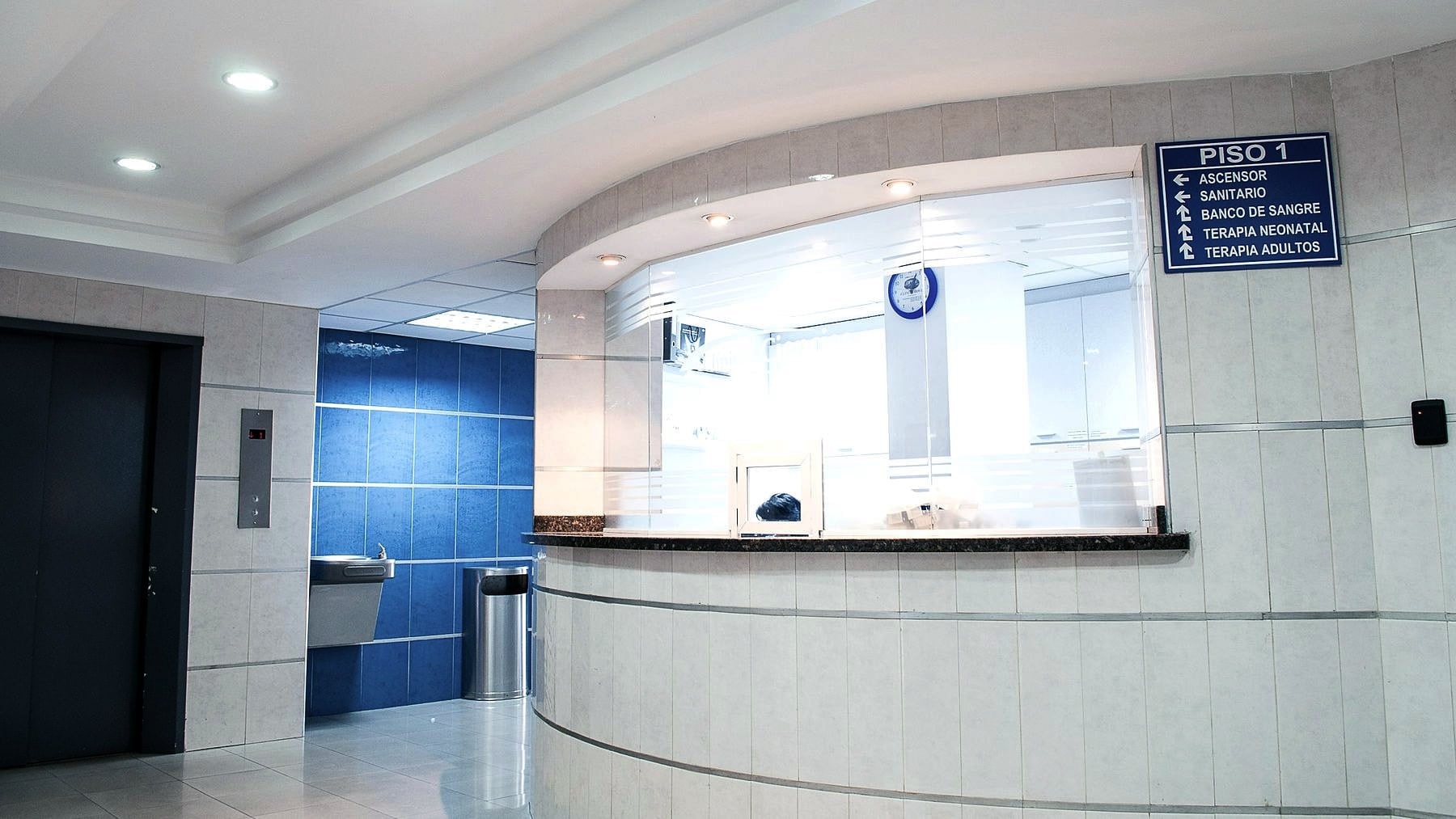 An empty hospital reception desk under clinical lighting