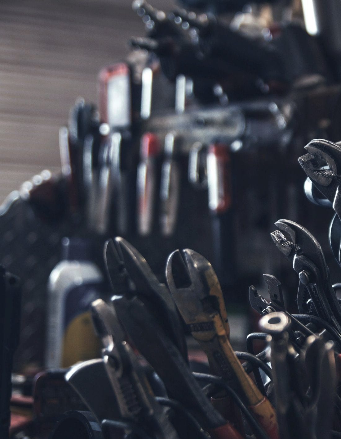 Pliers and hand tools racked in rows on a workshop wall