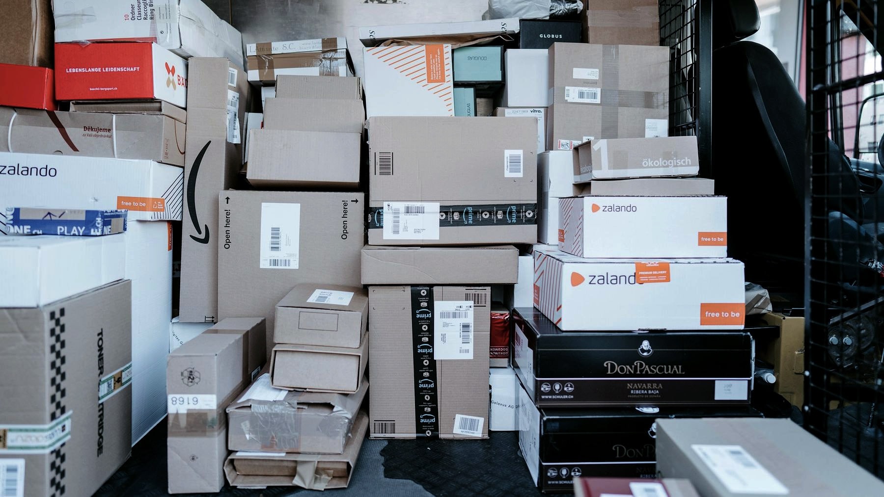 Parcels and boxes piled without order against a wall