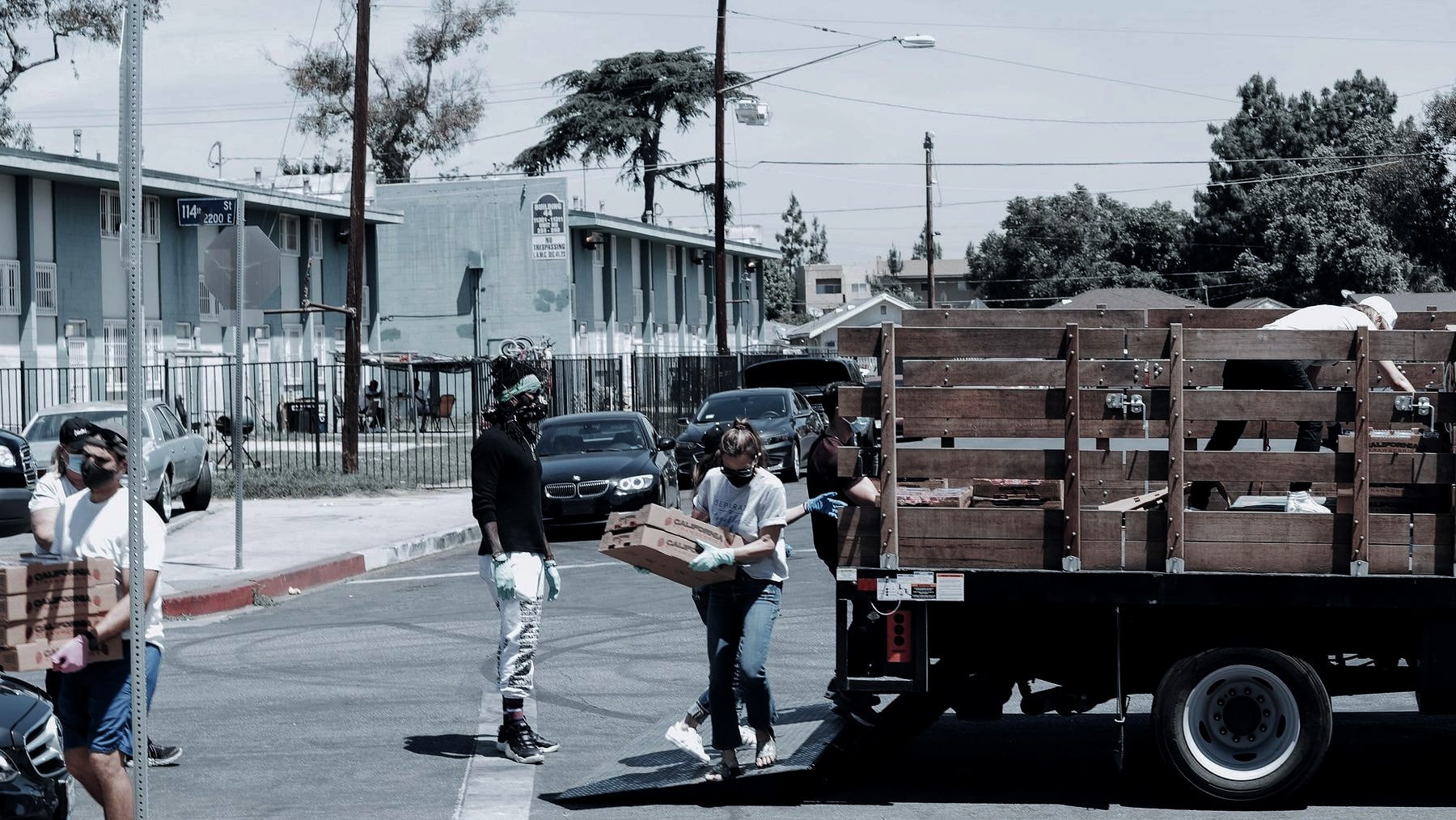Volunteers loading boxes onto a flatbed truck in the street