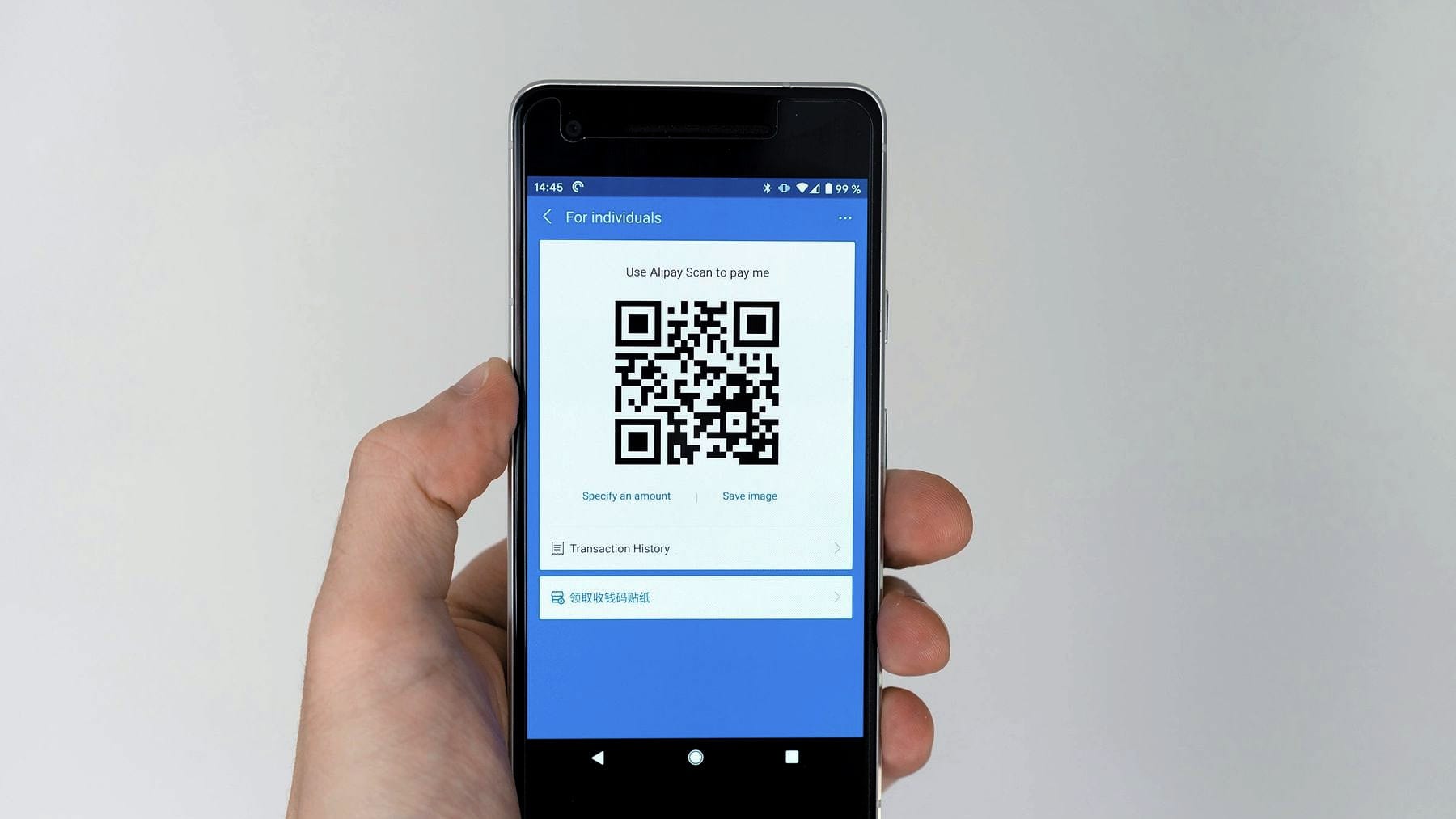 A phone held up scanning a QR code on screen