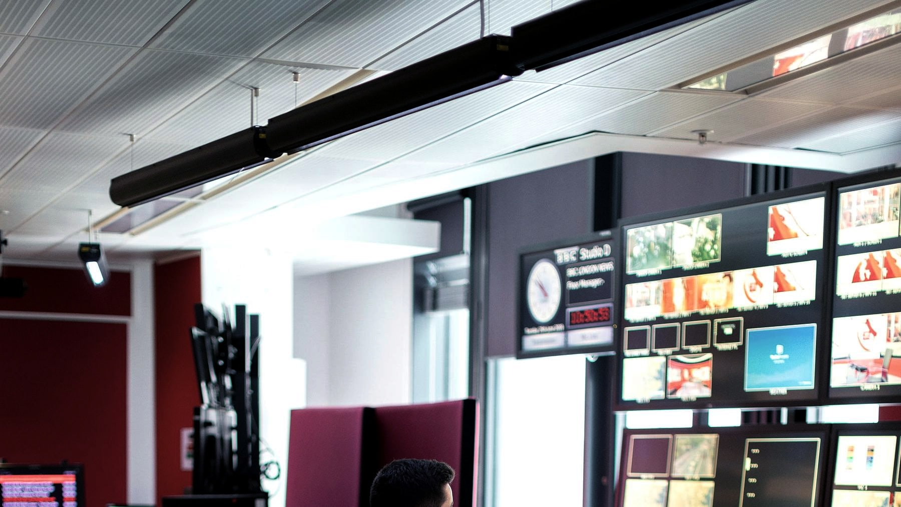 Operators working a control room lined with monitoring screens