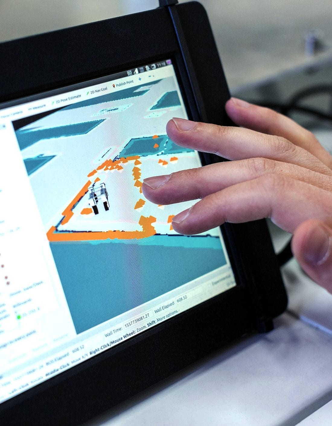 A hand working a rugged tablet showing a site drawing