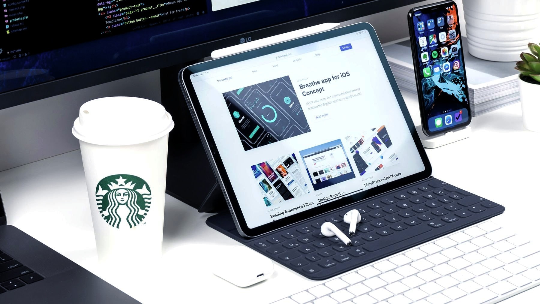 A desk with a page design open on the monitor and a phone alongside